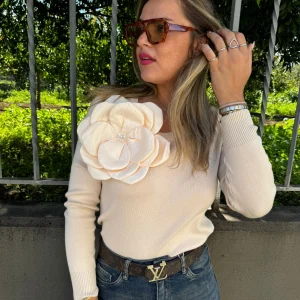 Maglioncino giro collo con fiore sul lato